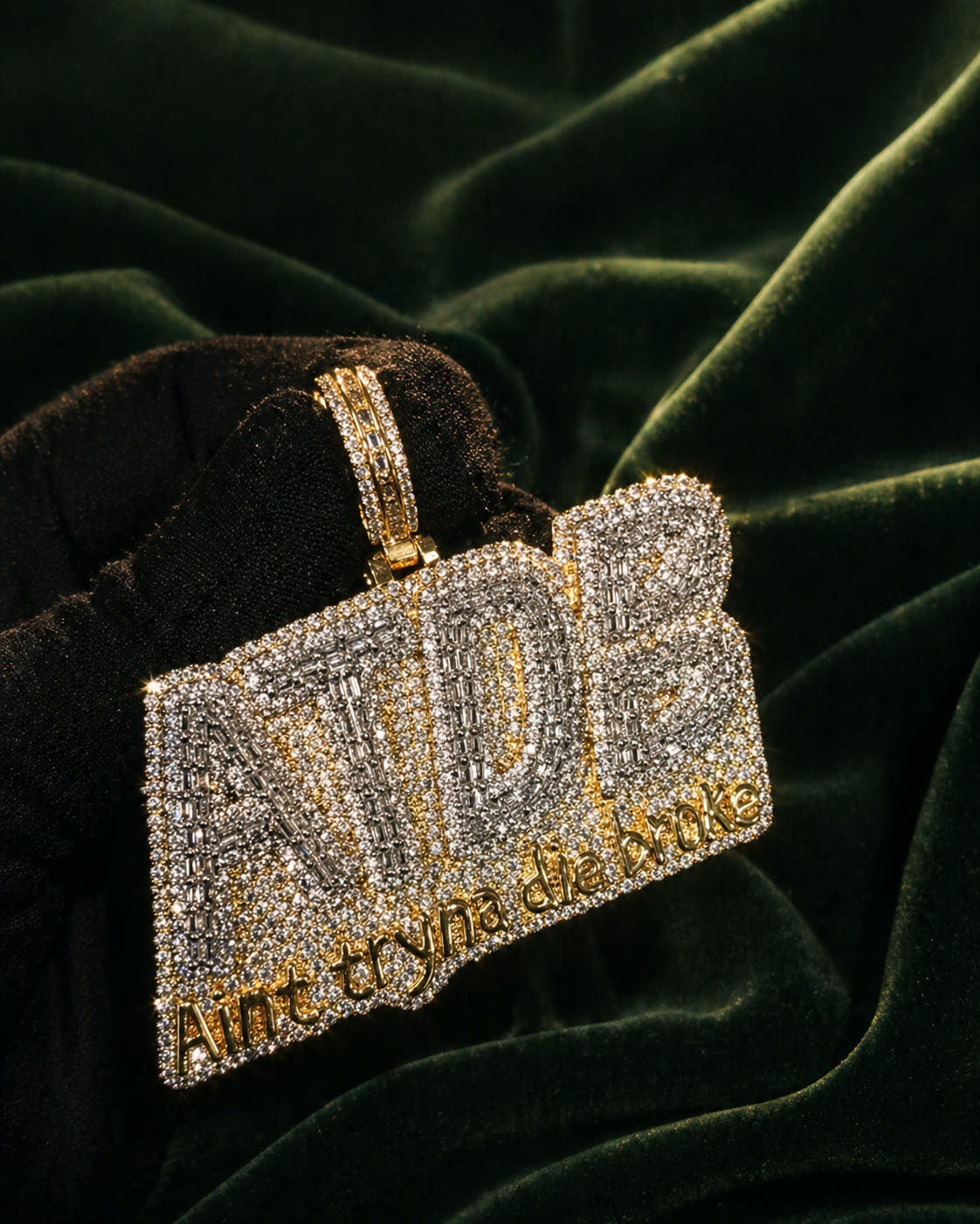 Custom ATDB block pendant in two-tone gold with engraved tagline, hand-set diamonds, on forest velvet.